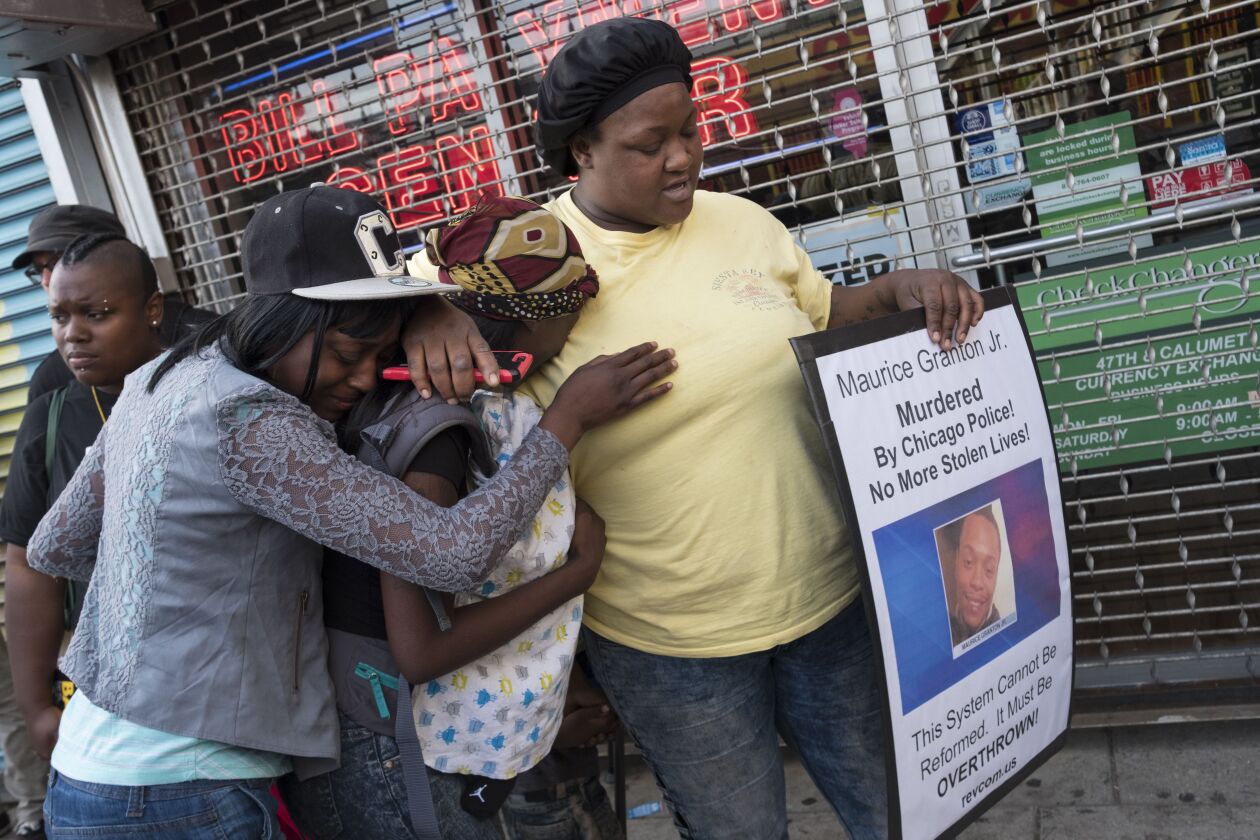 At a Thursday night vigil on 47th and Prairie, Shaumanika Jones (right) comforts Teresa Richardson (center), who is Maurice Granton Jr.’s sister. Granton was fatally shot by a Chicago Police officer Wednesday night during a Bronzeville foot chase. | Rick
